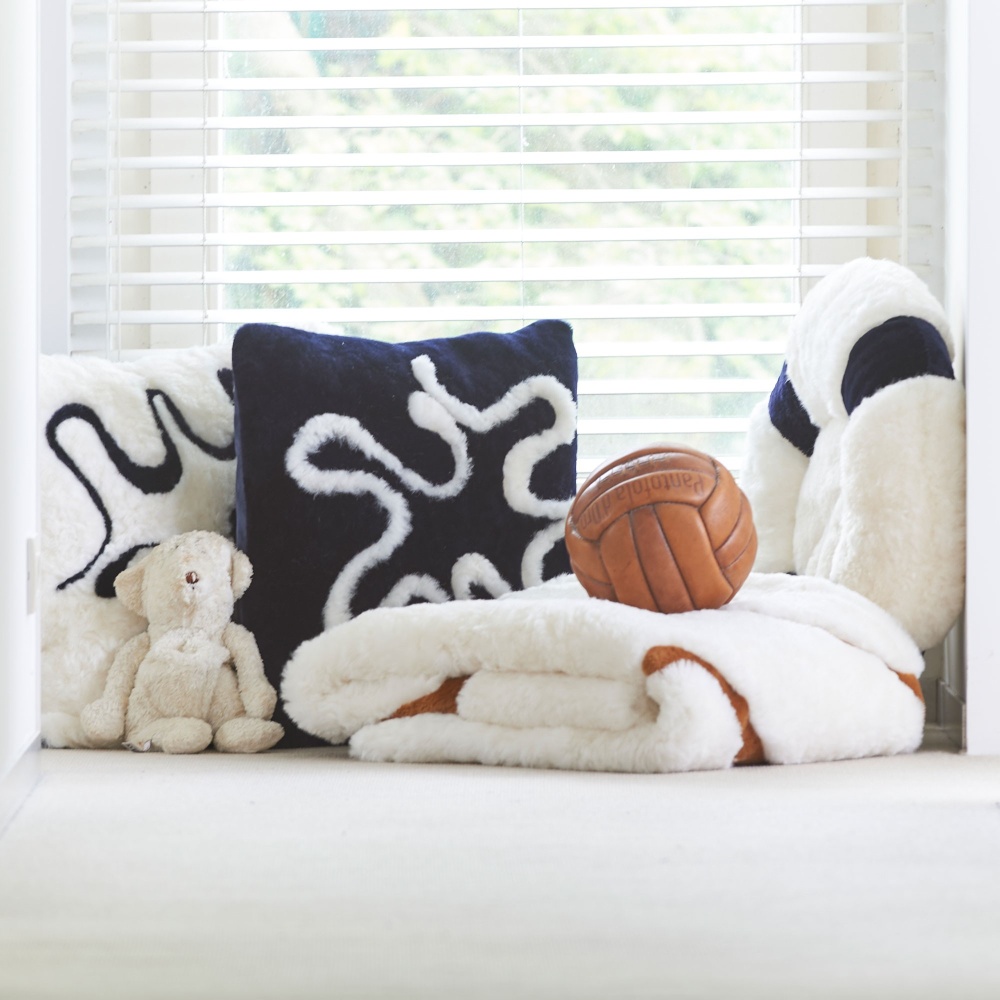 Navy blue and white cushion and throw in the very refined Ralph Lauren style for a Hamptons style home