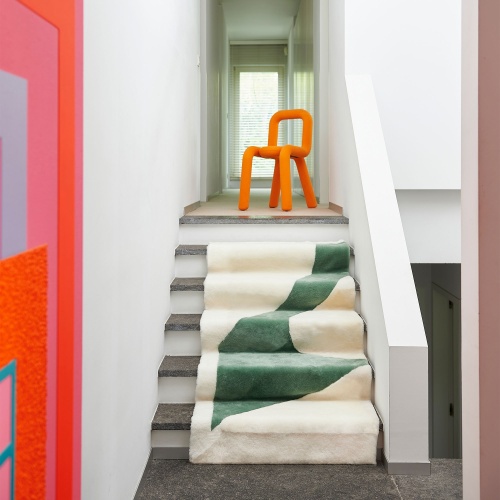 Orange Mustache chair, artwork by Peter Halley and white and green throw by Norki