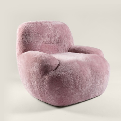 Petit fauteuil rose confortable tout en rondeur, monté sur une base rotative en métal. Pièce de mobilier est produite par Norki.