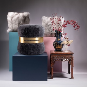 Norki stool in gray Australian curly lambskin with brass ring and high-end finish.