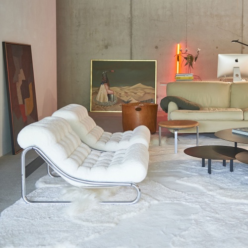 Comfortable armchairs in a vintage living room with a large white Khan rug.