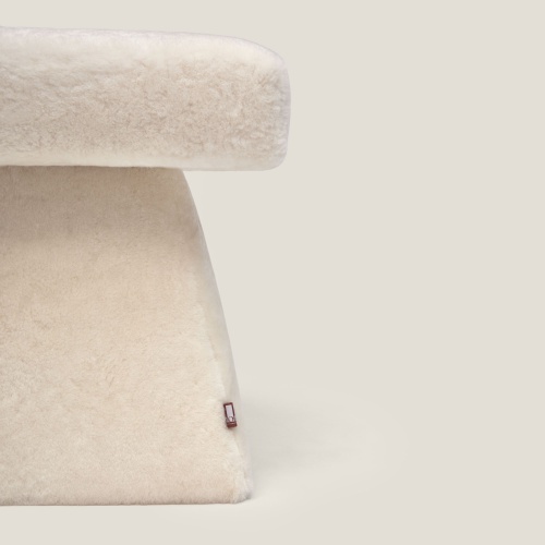 Small high-end seat covered in white shearling, available to measure.