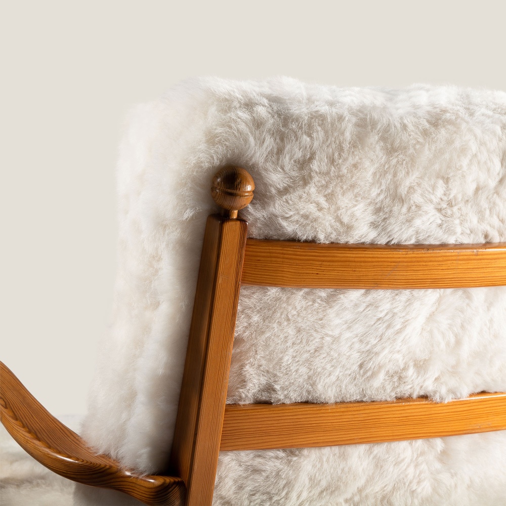 Pine armchairs with seat and back cushion in natural white sheepskin.