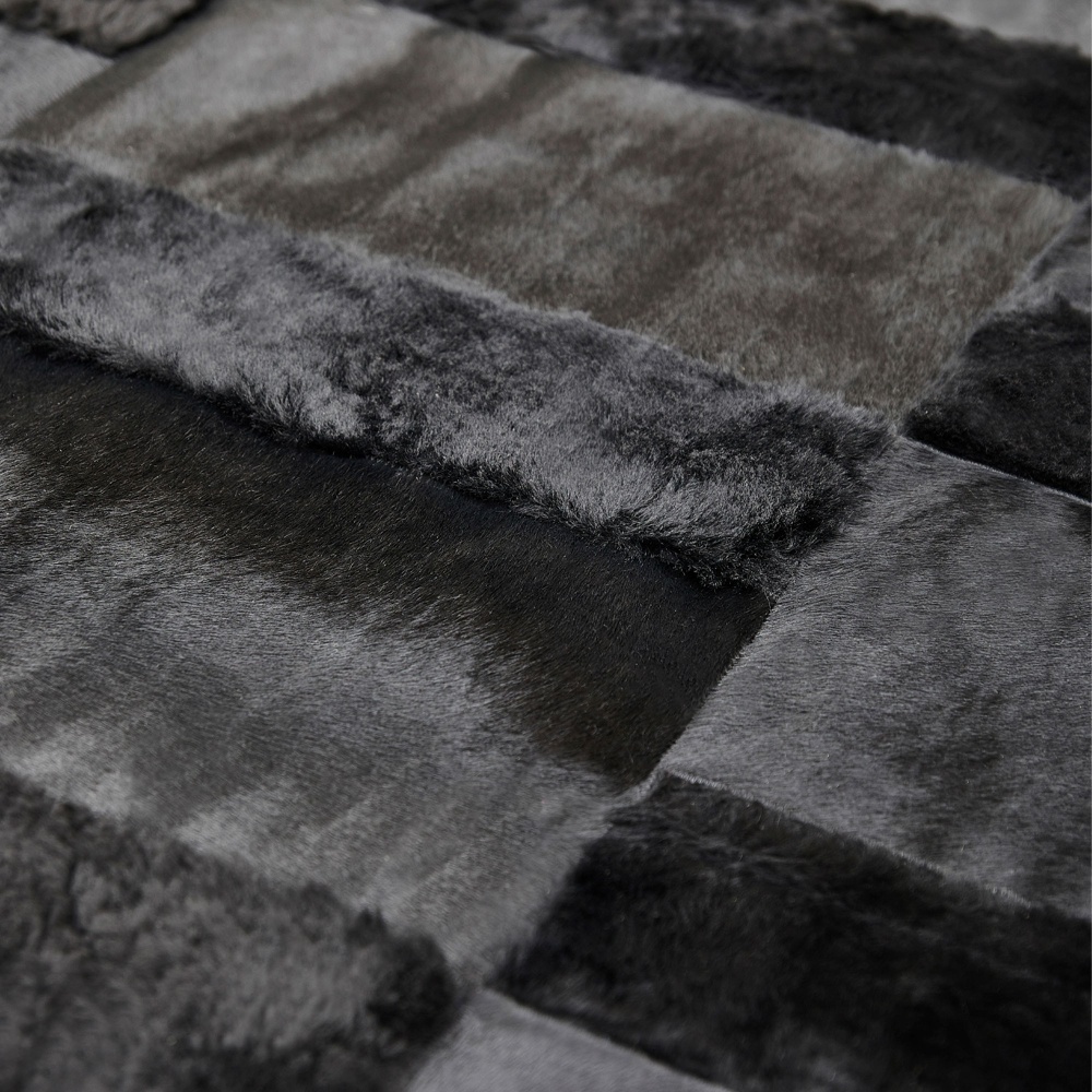 Black shearling and black foal rug with contrasting geometric repeating patterns.