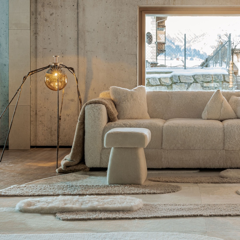 Rug in a soft and calm chalet atmosphere, with hide sofa and stool and a Louise Bourgeois lamp