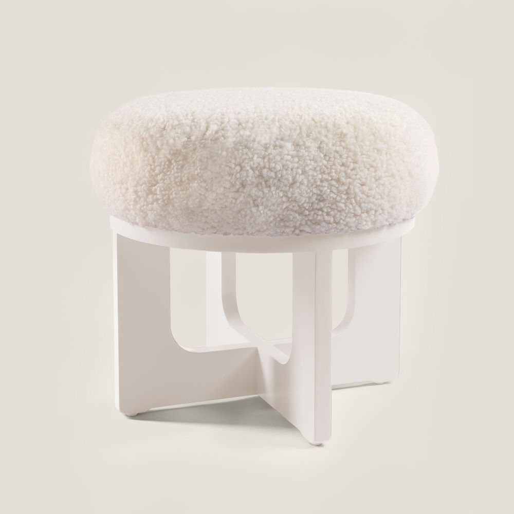 Shop a small white Norki pouf in lacquered wood and luxurious sheepskin for comfortable seating