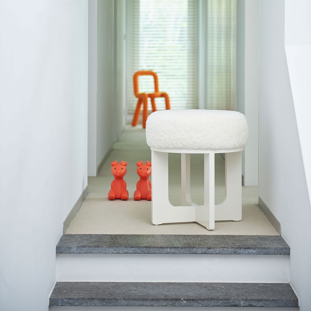 Orange mustache chair, vintage Ikea piggy banks and very contemporary white pouf