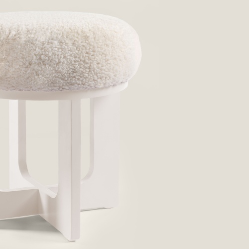 Grand pouf blanc de luxe de grande qualité avec des pieds en bois laqué et une assise en peau lainée