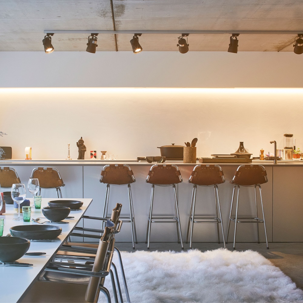 Stools by Charlotte Perriand coupled with an elegant, dense and comfortable white rug for a kitchen interior design