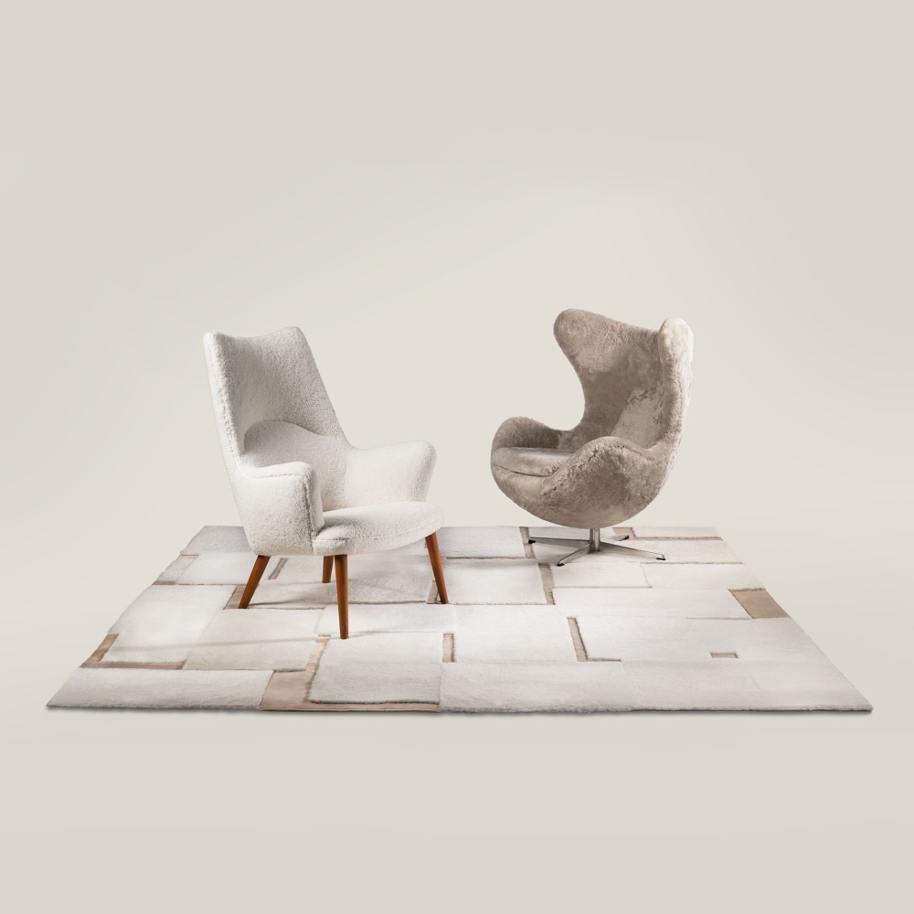 Ambiance douce avec un tapis haut-de-gamme et des fauteuils vintage de collection Hans Wegner et Arne Jacobsen.