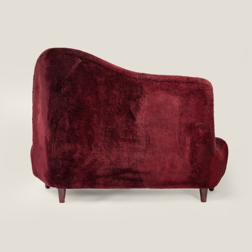 Small vintage sofa in burgundy sheepskin with asymmetrical high back