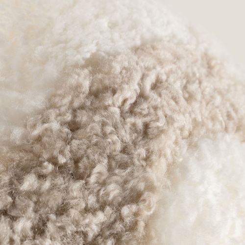 Natural white and oat-tinted Australian curly shearling cushion.