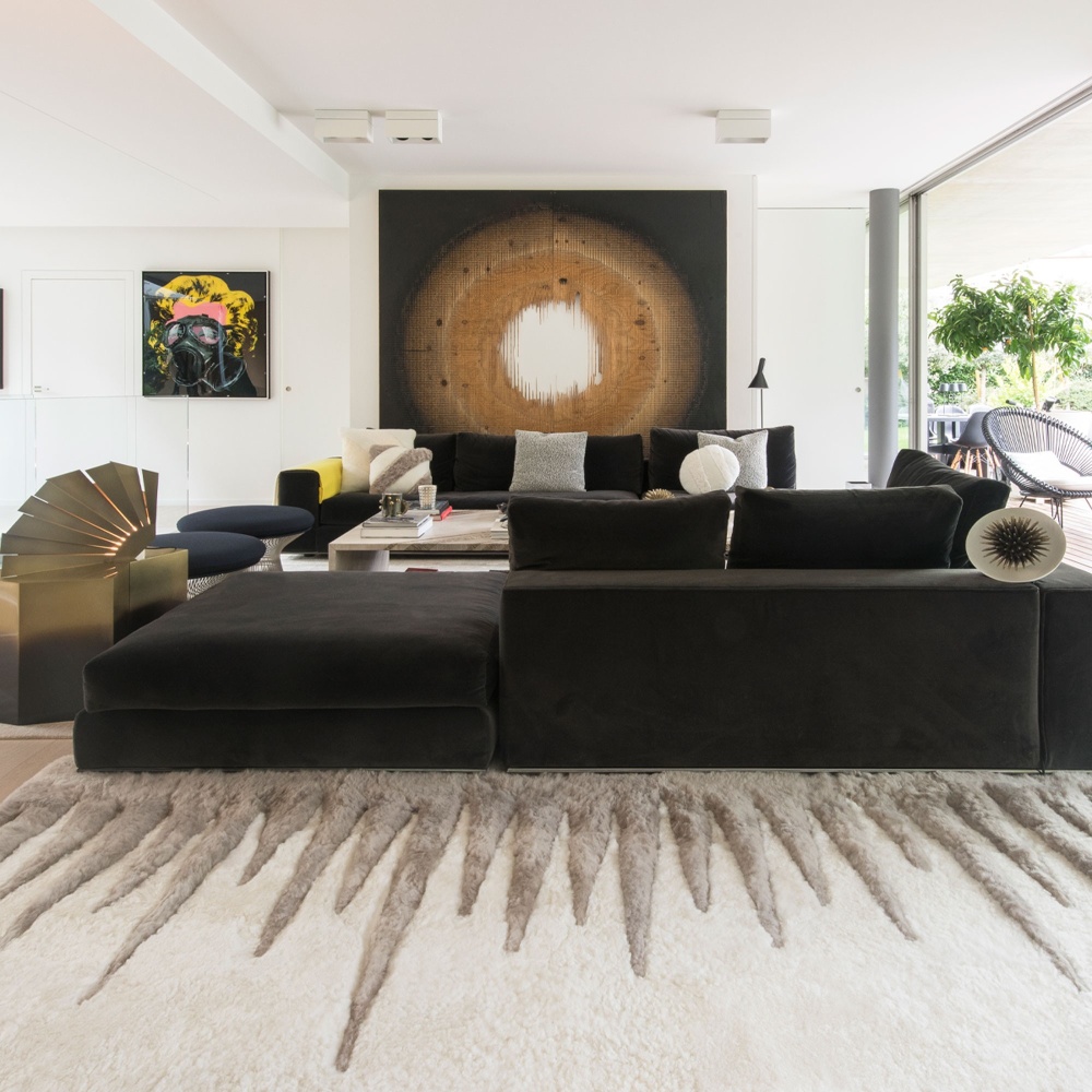 High-end contemporary interior decoration by Maison Norki in Geneva with this large beige and white rug and a designer sofa.