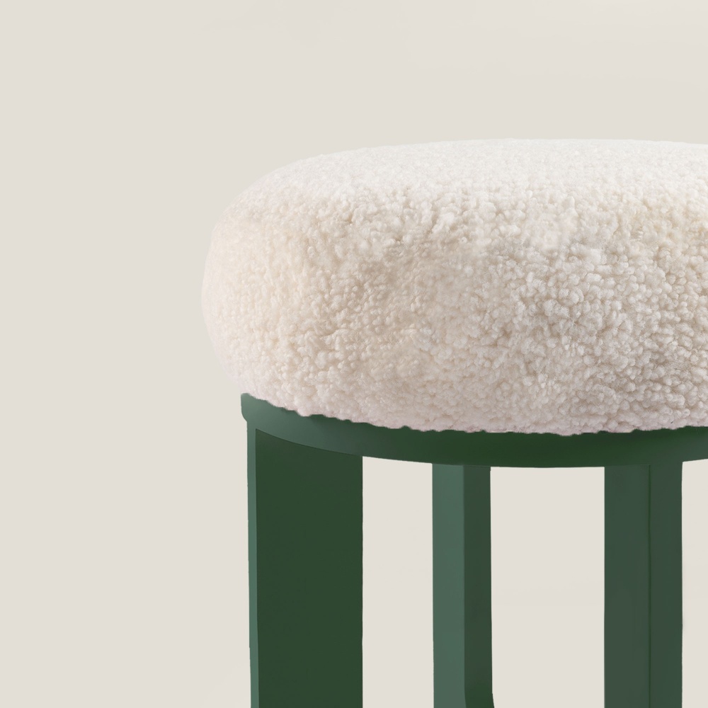 Une assise confortable et moelleuse en peau lainée blanche pour ce pouf haut de gamme