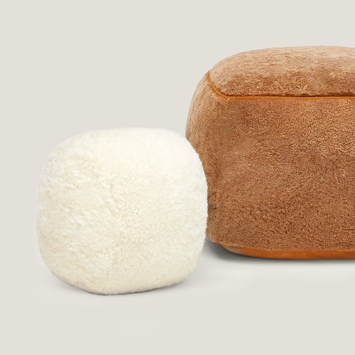 Coussin luxueux blanc et pouf camel.