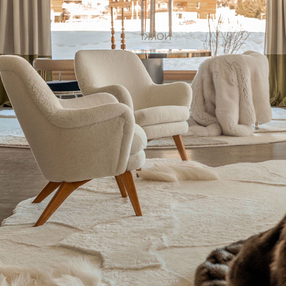 Tapis Khan tout en relief et fauteuils blancs vintage dans notre boutique de Gstaad en Suisse