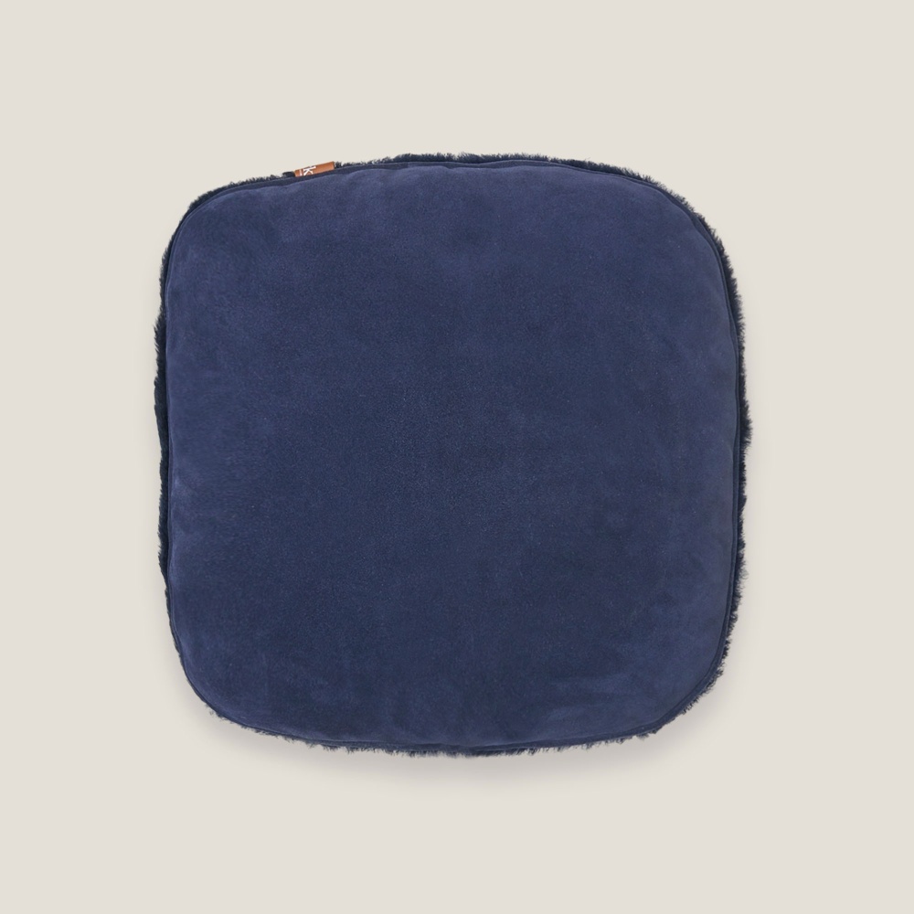 Dos de coussin en cuir suédé bleu foncé.