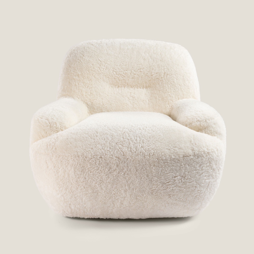 Fauteuil confortable en peau lainée blanc, L 88 × H 74 × P 80 cm. Fabriquée par Norki, une manufacture française de mobilier.