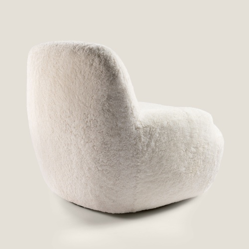 A small, luxurious armchair with a simple, minimalist design. A small masterpiece of upholstery from the Norki workshops.