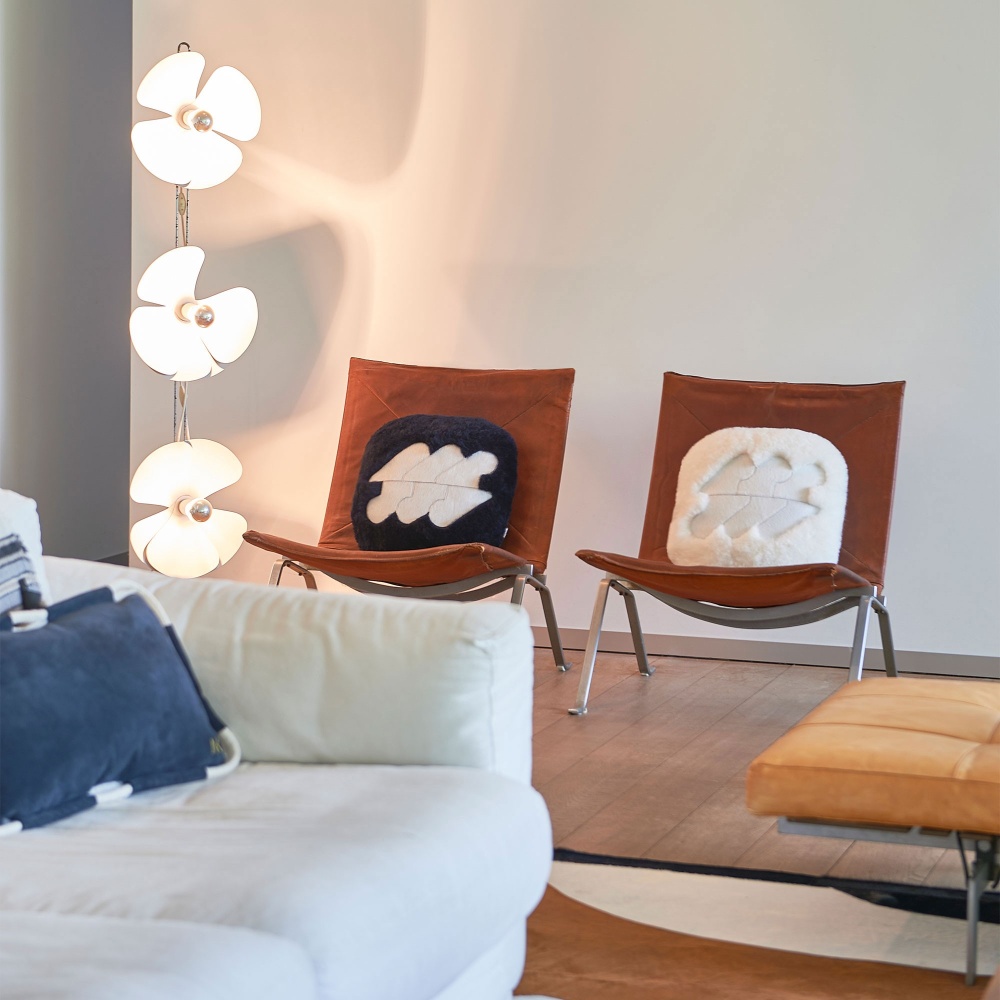 White and beige natural curly shearling cushion on a leather armchair.