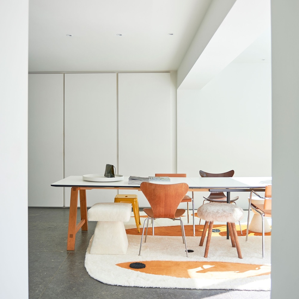 Modern dining room decorated with a contemporary rug with organic shapes and vintage chairs