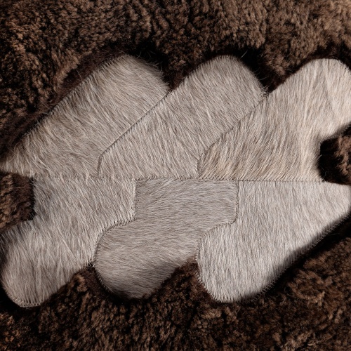 Brown curly shearling cushion with a beige and white mottled natural cowhide pattern.