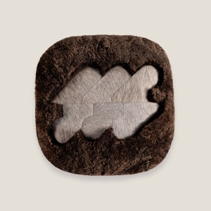 Coussin haut-de-gamme en peau lainée marron foncé et peau de vache beige par les ateliers Norki