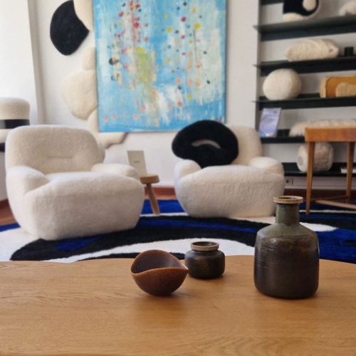 Ceramic vases, stoneware bowl, and white Bao armchairs.