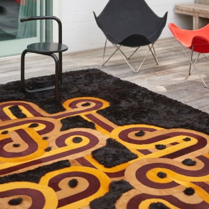 Rectangular rug with a very colorful abstract pattern on a natural black sheepskin background - Artistic collaboration.