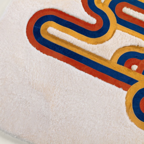 Rug with central pattern in orange, saffron and blue cowhide, and natural white sheepskin background.