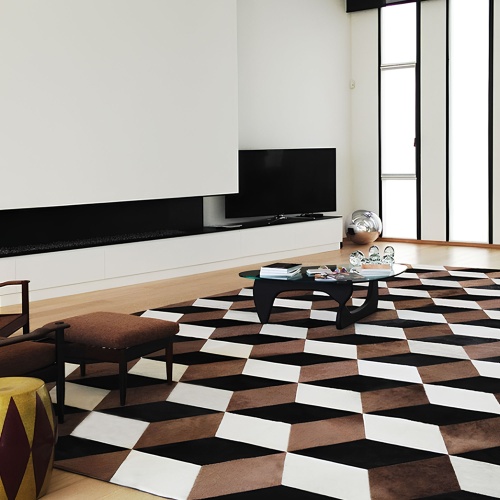 Tapis au motif cubique dans un intérieur aux murs blancs, Table basse de Isamu Noguchi.