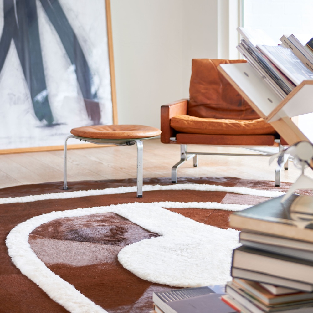 Grand tapis moderne dans un salon avec fauteuil en cuir Camel Poul Kjaerholm