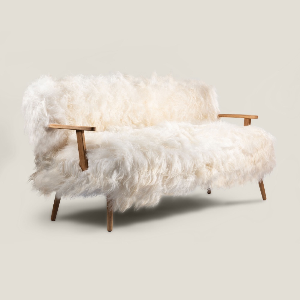 White sheepskin sofa with tapered legs. Sizes W 2,3 × H 3 × D 2,5 ft. A Maison Norki signature.