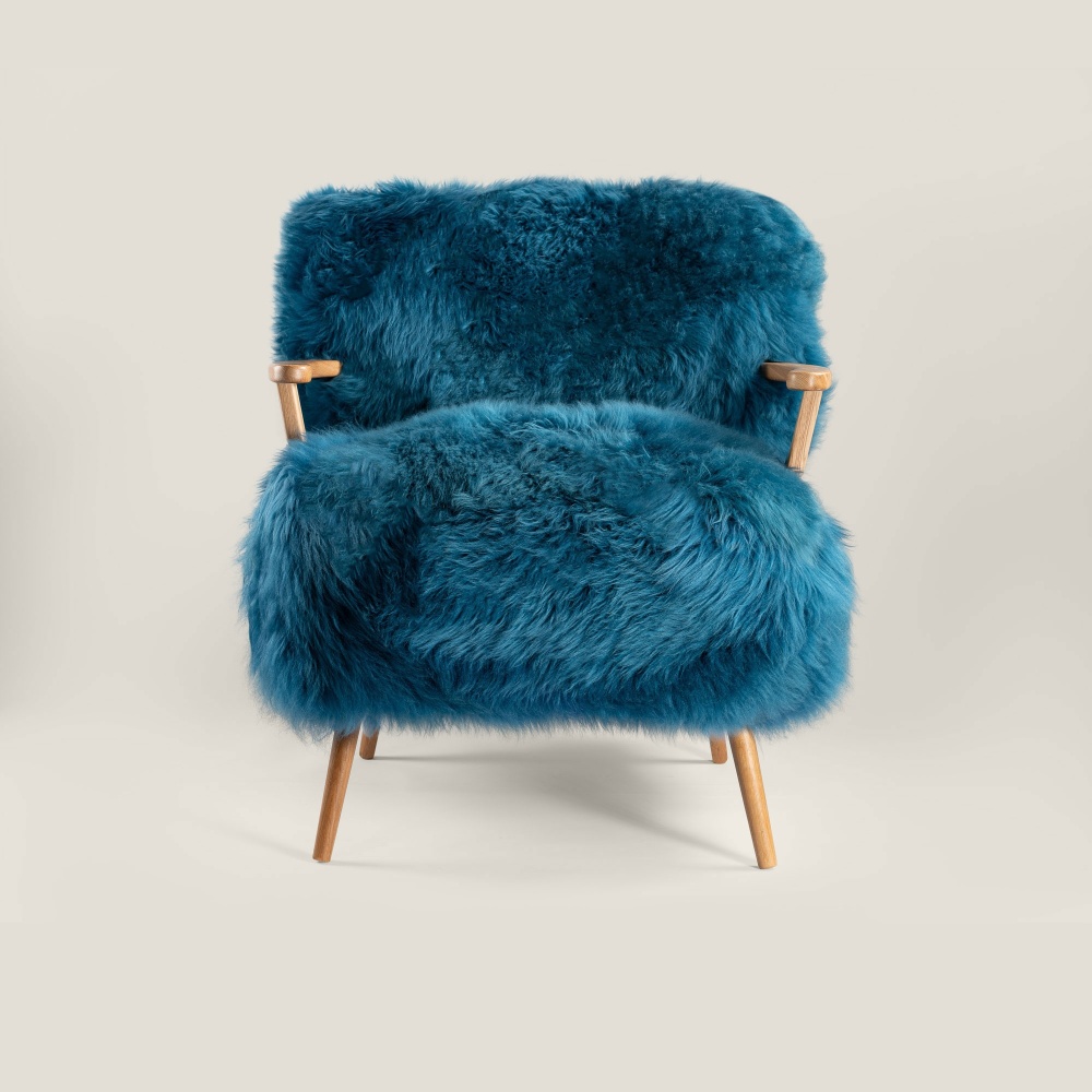 Blue armchair in sheepskin and solid oak with timeless elegance and contemporary Scandinavian design.