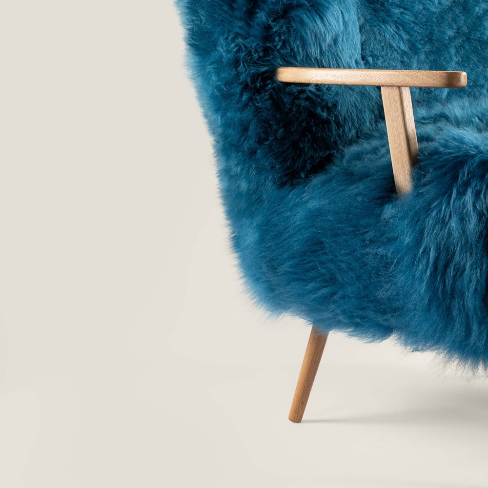 Large, comfortable blue designer armchair in solid oak and blue-dyed sheepskin, with exceptional, luxurious finishes.