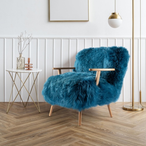 Dans un intérieur contemporain, ce fauteuil bleu posé sur un joli parquet à chevron en chêne massif impose son style élégant.