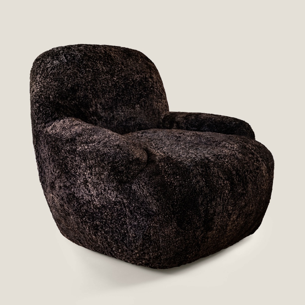 Fauteuil marron foncé recouvert de shearling curly marron foncé et posé sur un système pivotant en métal fabriqué en France.