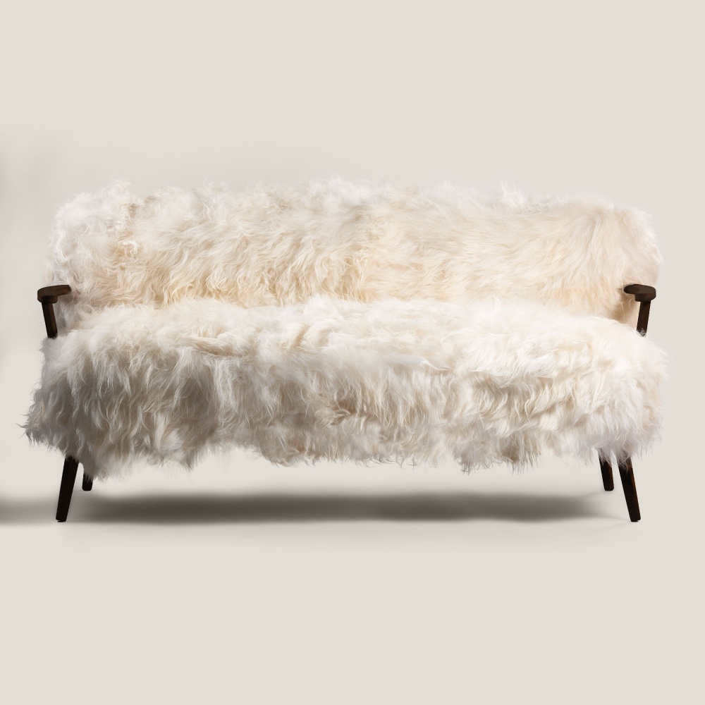 Elegant sofa in white Icelandic sheepskin and solid black oak. The perfect design for your mountain chalet.