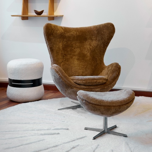 Décoration urbaine avec fauteuil Egg vintage Arne Jacobsen, pouf noir et blanc design et tapis rond blanc.