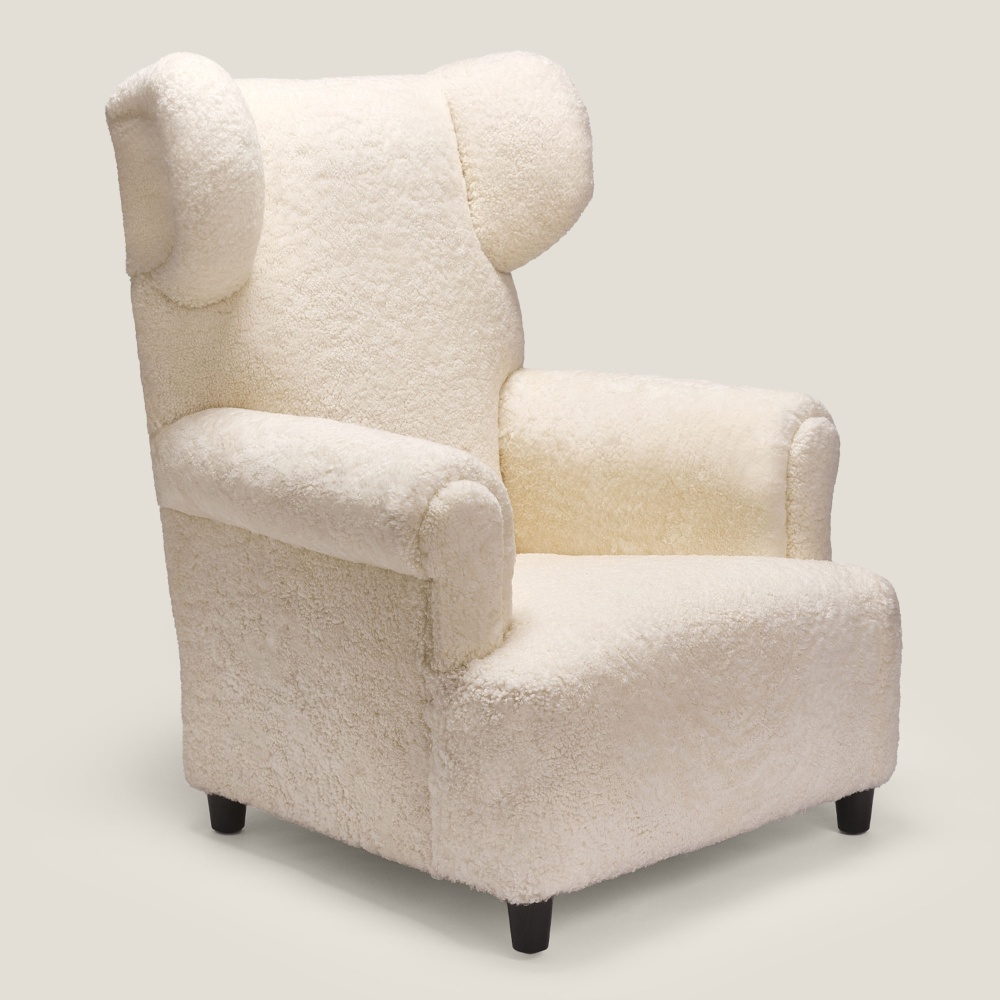 White wing designer armchair made in France: a luxurious reading chair for your living room upholstered in shearling .