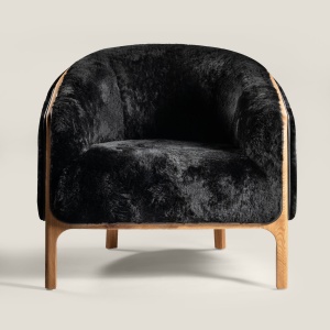 Luxurious, modern, wrap-around NORKI armchair upholstered in black leather or seharling. Ideal for your living room or bedroom.