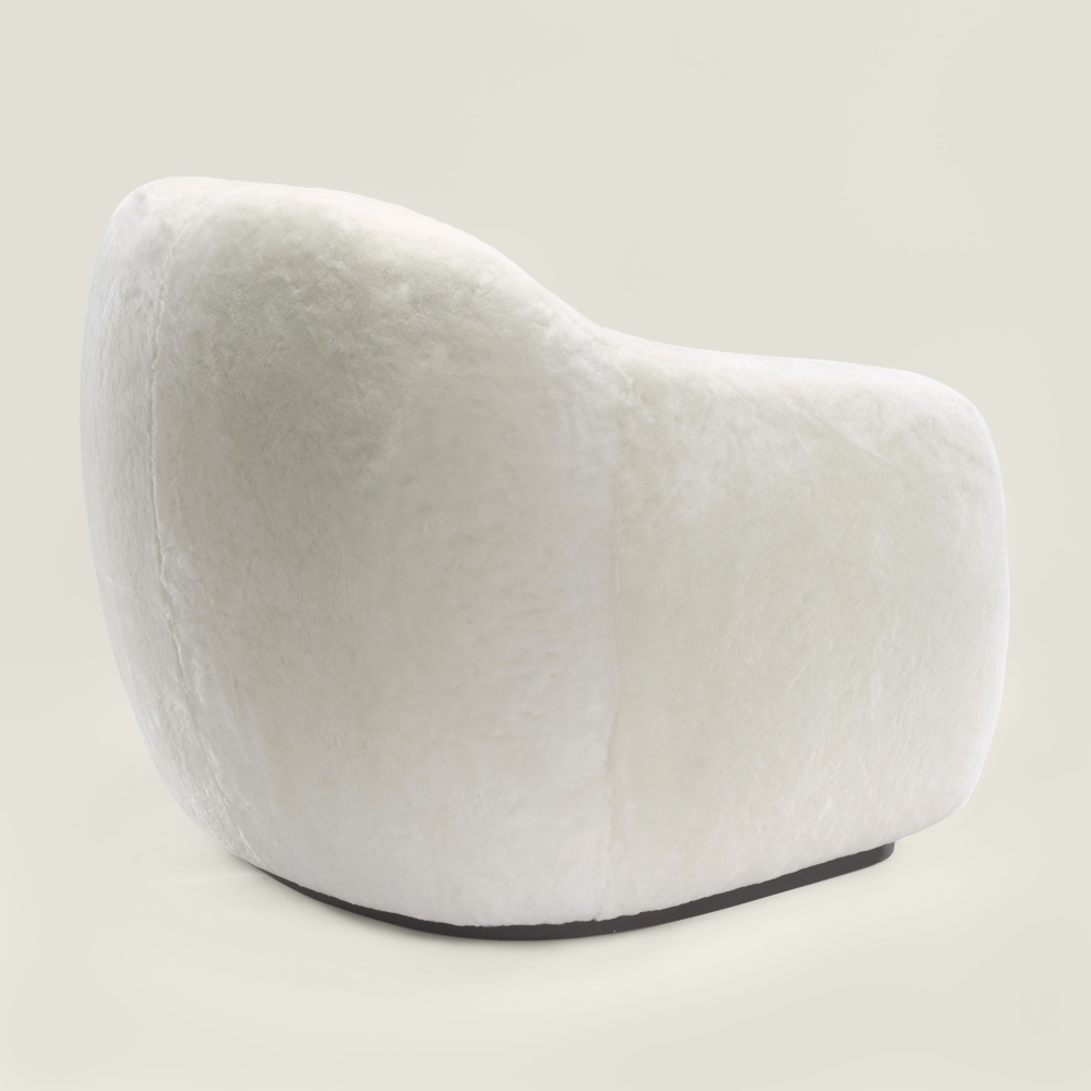 Un fauteuil blanc aux proportions généreuses, aux courbes enveloppantes et élégantes pour un confort absolu.