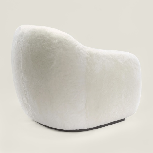 A white armchair with generous proportions and elegant, wraparound curves for absolute comfort.