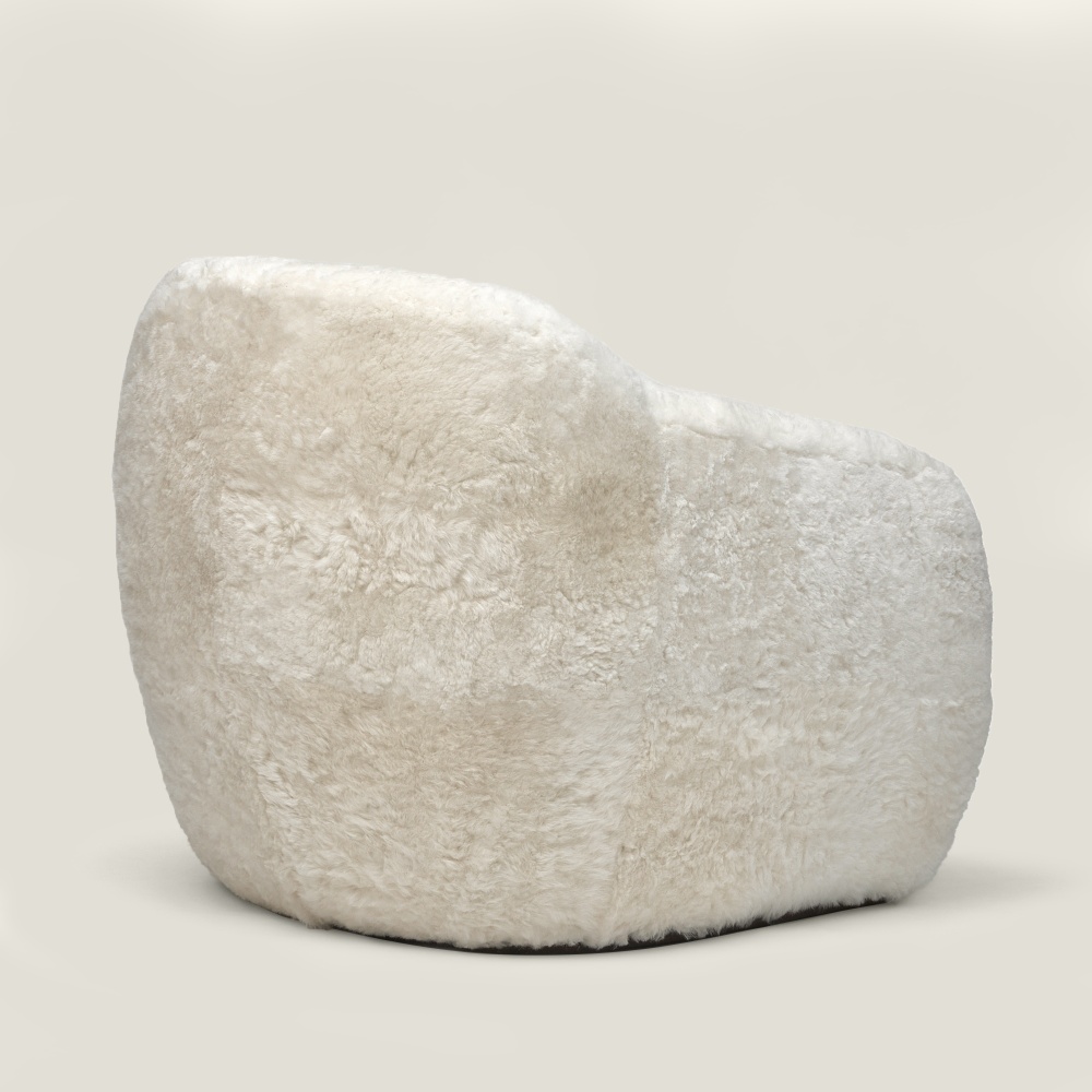 Fauteuil blanc design aux élégantes courbes enveloppantes entièrement gainé de mouton blanc. Un style parfait pour votre chalet.