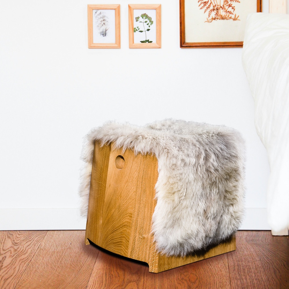 Decorate your home with this small, elegantly designed pouffe in solid wood and sheepskin.