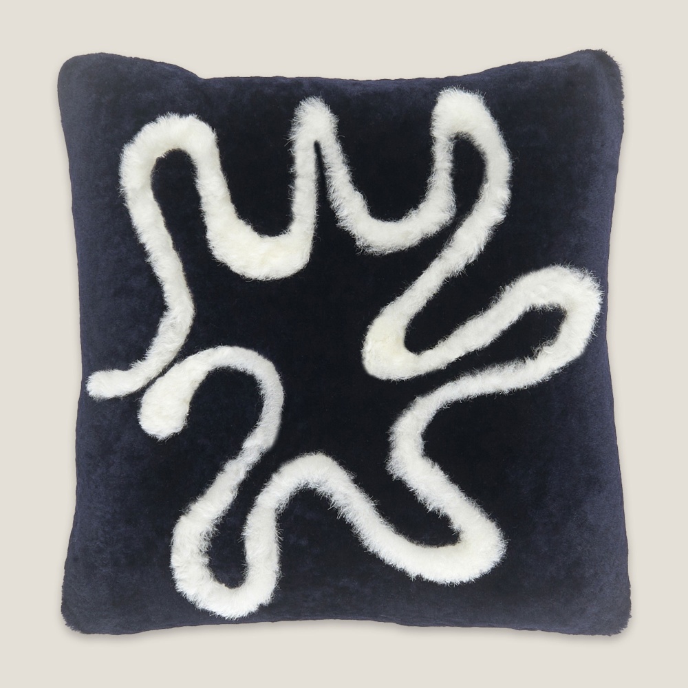 A square shape, navy blue cushion with a white pattern reflecting the waves of the North Sea. Inner feather cushion.