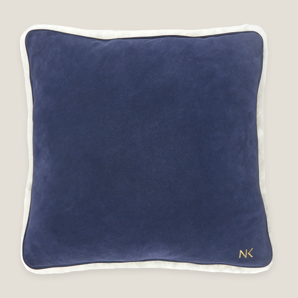 L'une des faces du coussin est entièrement bleue, sans motif, et contraste avec la face blanche.