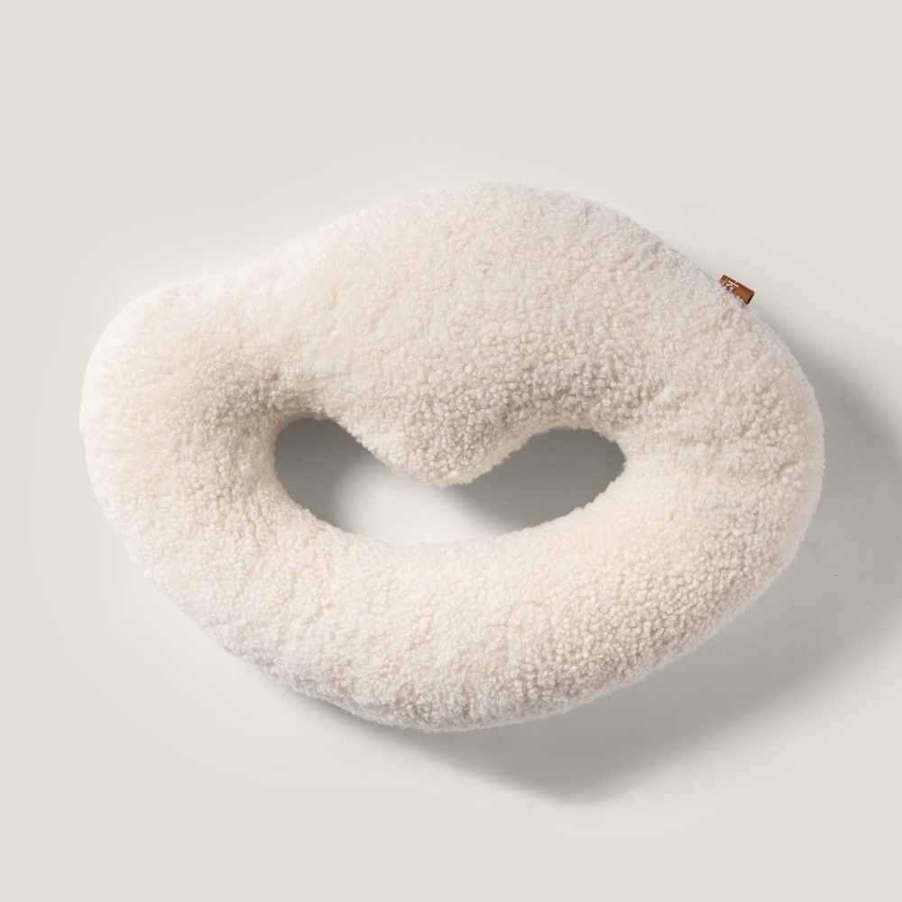 White ring-shaped cushion in curly shearling.