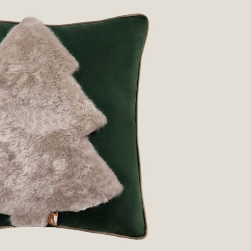 Coussin en laine verte avec une application en motif abstrait de sapin en peau lainée