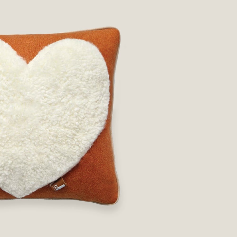 Coussin orange safran carré luxueux avec un grand coeur en peau lainée blanche